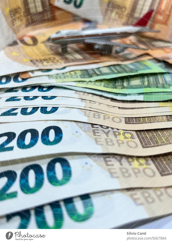Nahaufnahme von 200-Euro-Banknoten mit einem verschwommenen Flugzeug auf der Rückseite, das den Luftverkehr verteuert Geld fliegen Rechnung Pilot vereinzelt