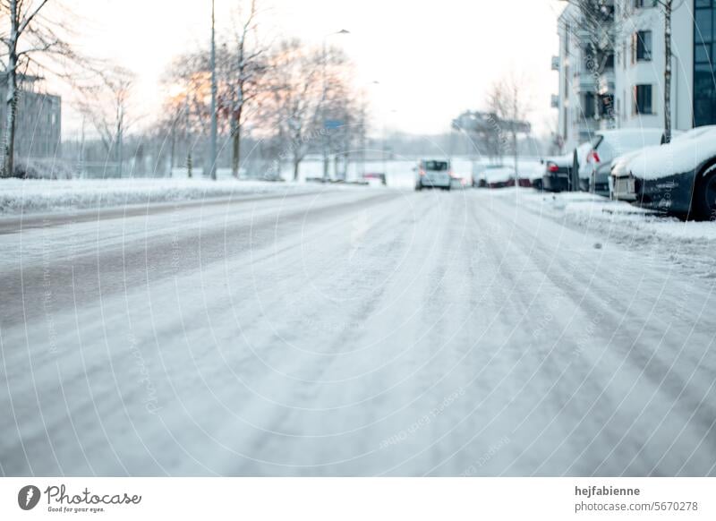 Winterliche Straße mit parkenden Autos in städtischem Wohngebiet Wintermorgen schneebedeckte Straße winterlich Frost Eis verschneit Schnee städtische Straße
