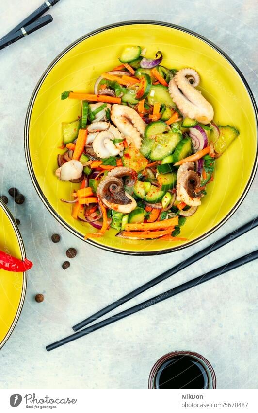 Oktopus-Salat mit Gurke, koreanisches Essen. Salatbeilage Octopus Meeresfrüchte Tintenfischsalat Lebensmittel Teller flache Verlegung Salatgurke Draufsicht