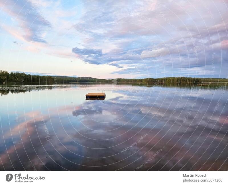 Schwimmende Insel in Schweden auf einem See bei Sonnenuntergang. Die Wolken spiegeln sich im Wasser. Schwimminsel Holzinsel Stille Schwimmvergnügen Paradies