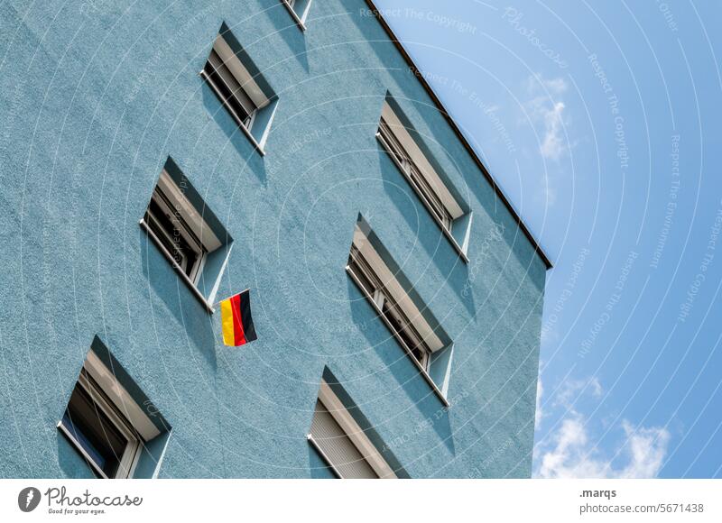 Typisch deutsch | ein bisschen Patriotismus Froschperspektive Haus Mehrfamilienhaus blau Himmel Schönes Wetter Fenster Deutsche Flagge Fahne Fähnchen