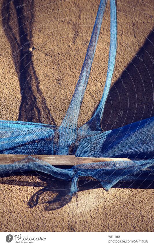 Von einem blauen Gerüstnetz, innerlich zerrissen und vom Wind gebeutelt, welches sich noch einen verschlissenen Rest von Achtsamkeit bewahrt hat kaputt