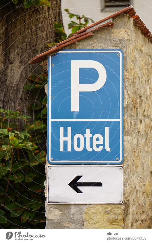 blaues Schild  P Hotel mit Pfeil an einer Wand Parkplatzschild hoteleigener Parkplatz nur für Hotelgäste Parkplatz für Hotelgäste Parkmöglichkeit