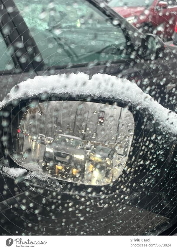 Nahaufnahme eines Autospiegels mit Schnee zwischen den Spritzern auf dem Glas Unwetter Frost PKW Saison Winter eisig frieren kalt Spiegel Temperatur Schneesturm