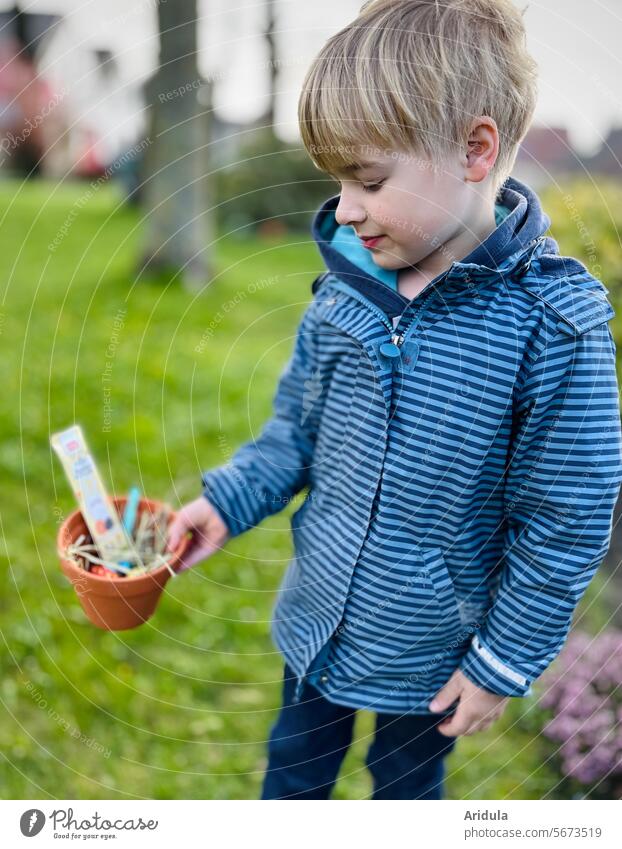 Ostern | Kind hält einen Tontopf in der Hand in dem ein Osternest versteckt ist Ostereiersuche Nest Frühling Tradition Feste & Feiern Garten Freude Süßigkeiten