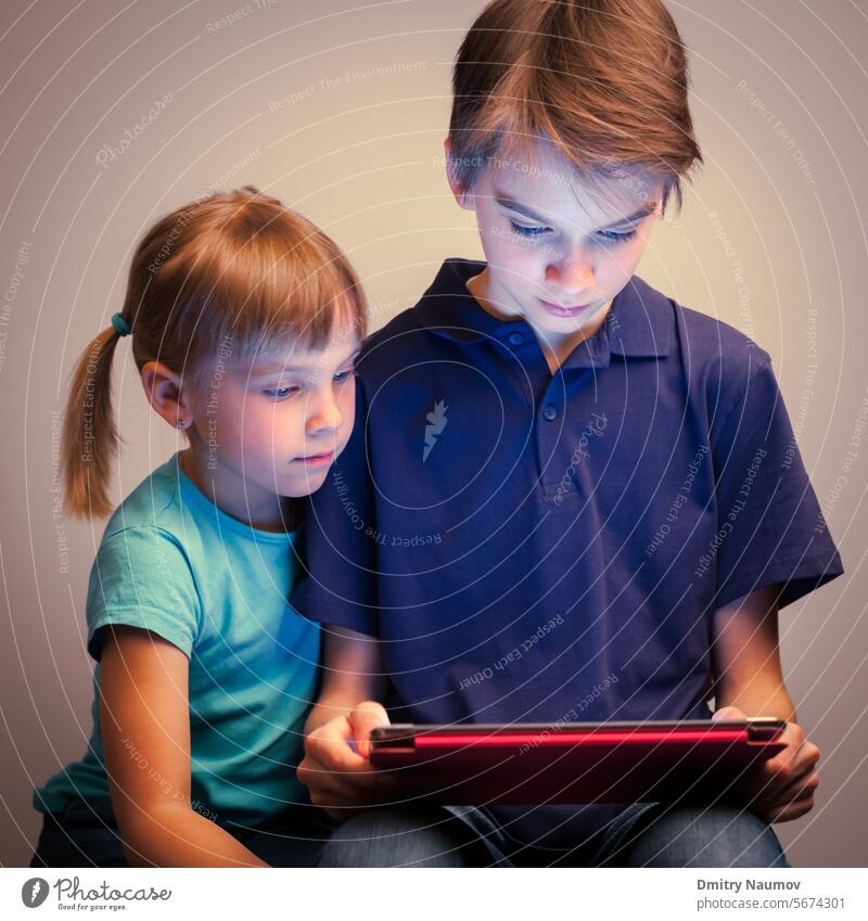 Geschwister, die einen Tablet-Computer benutzen Halbgeschwister Sucht Junge Bruder Freizeitkleidung Kaukasier Kindheit Kinder kooperieren niedlich Gerät digital