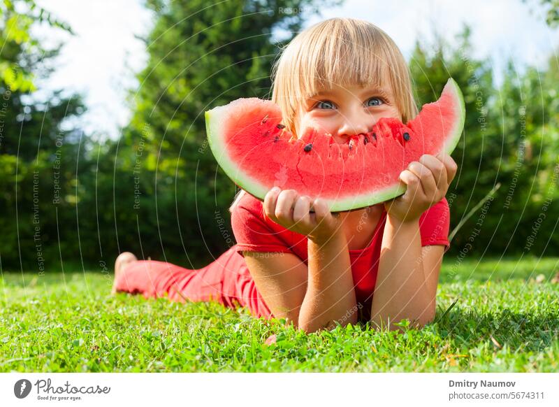 Kind mit Melonenscheibe im Freien in die Kamera schauen Appetit & Hunger blond Kaukasier niedlich lecker Dessert essen genießend Genuss Lebensmittel frisch