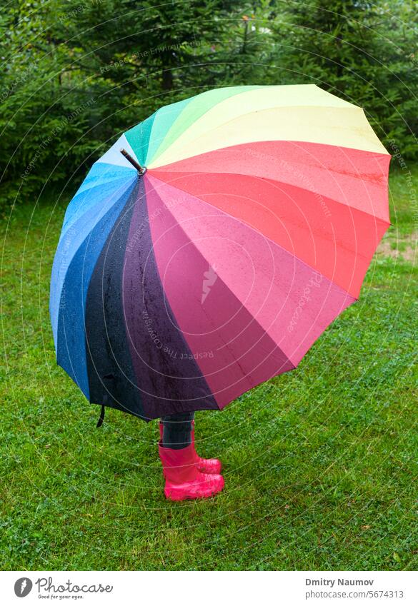 Kind mit Regenschirm im Freien Herbst Stiefel farbig Tropfen Prognose Mädchen Gras Gummistiefel versteckend Beteiligung wenig Wiese multi Natur eine Park