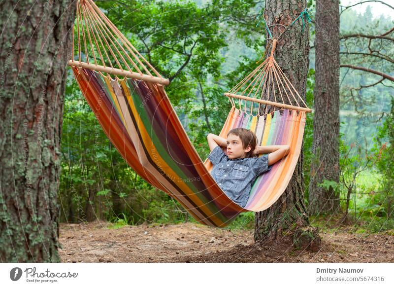 Kind entspannt sich in Hängematte im Freien 12 Jahre heitere Menschen Junge Windstille Lager Camping Campingplatz Kaukasier Kindheit bequem Tag Träume genießen