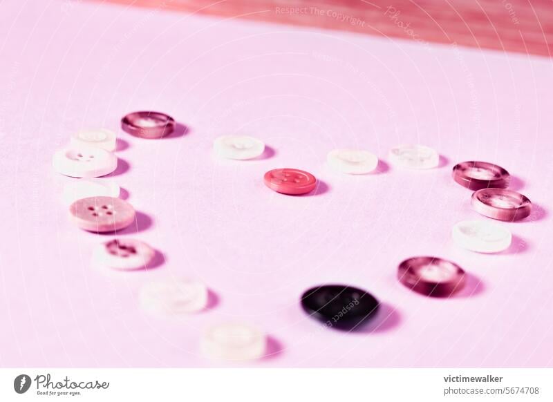 Herzform mit farbigen Knöpfen Liebe Hintergrund Rosa Farbe Symbol Valentinskarte romantisch Studioaufnahme Romantik Flitterwochen verliebend Hochzeit Geschenk