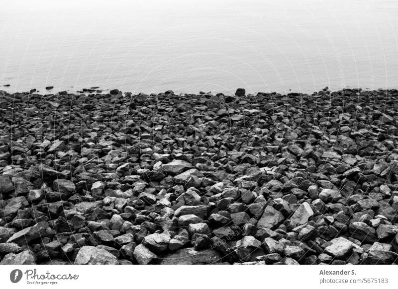 Steinstrand am Ufer Uferlinie Wasser Meer Steine Schotter grafisch Übergang Küste Strand Landschaft Küstenlinie Seeküste Meeresufer Meereslandschaft