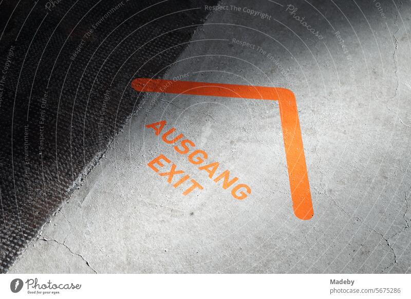 Besucherführung mit Pfeil in Orange auf grauem Beton in einer Ausstellung in den Ausstellungshallen am Schacht XII der Zeche Zollverein in Essen im Ruhrgebiet in Nordrhein-Westfalen in Deutschland