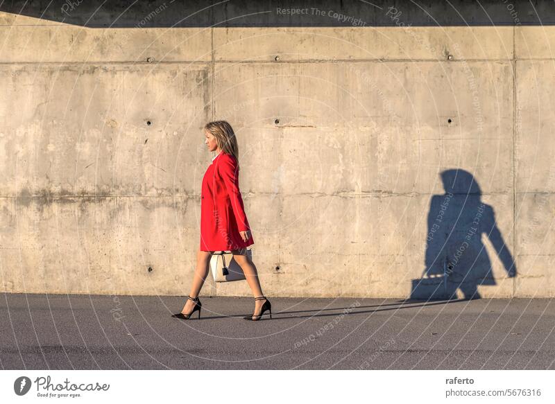 Seitenansicht einer Geschäftsfrau beim Spaziergang durch die Stadt rot Frau Business laufen im Freien Großstadt Erwachsener Erfolg Gebäude Lifestyle