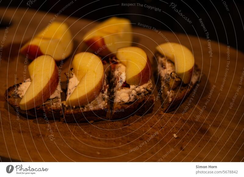 Brotzeit in dämmrigem Licht Holzbrett Apfel Mahlzeit Abendbrot Lebensmittel Ernährung Belegtes Brot Gesundheit Aufstrich Nahrung Essen