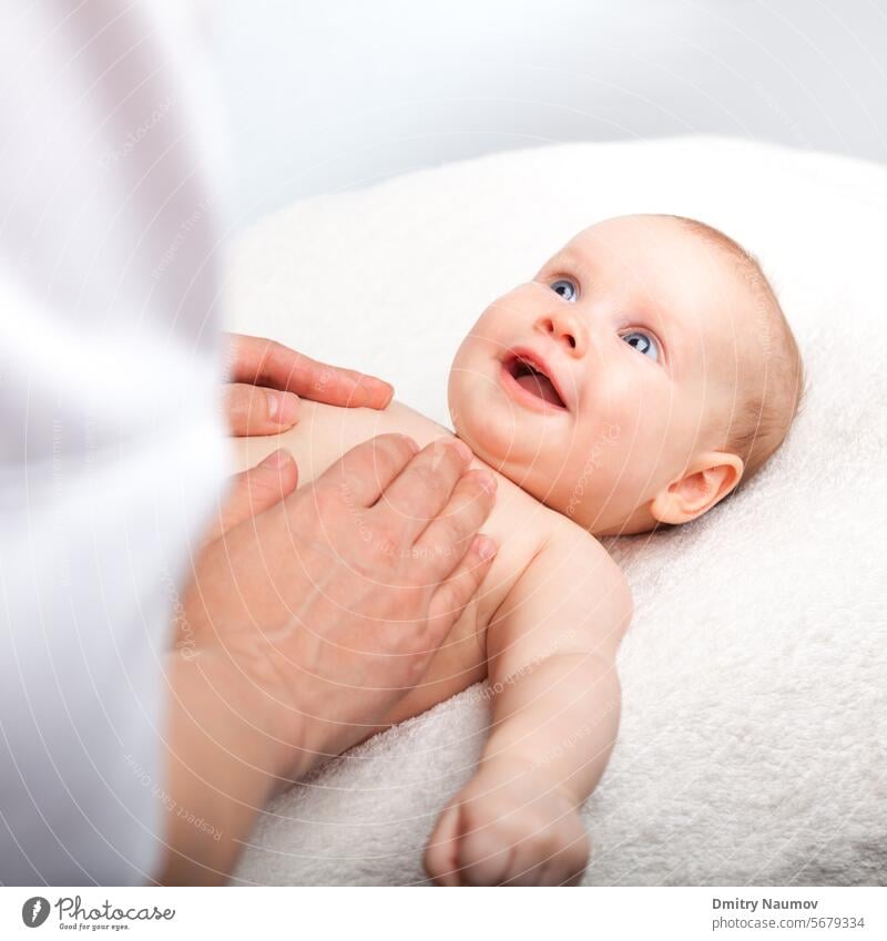 Ein drei Monate altes Mädchen wird von einer Masseurin an der Brust massiert 0-6 Monate Unterleib abdominal alternativ Baby Körper Pflege Kaukasier Truhe Kind