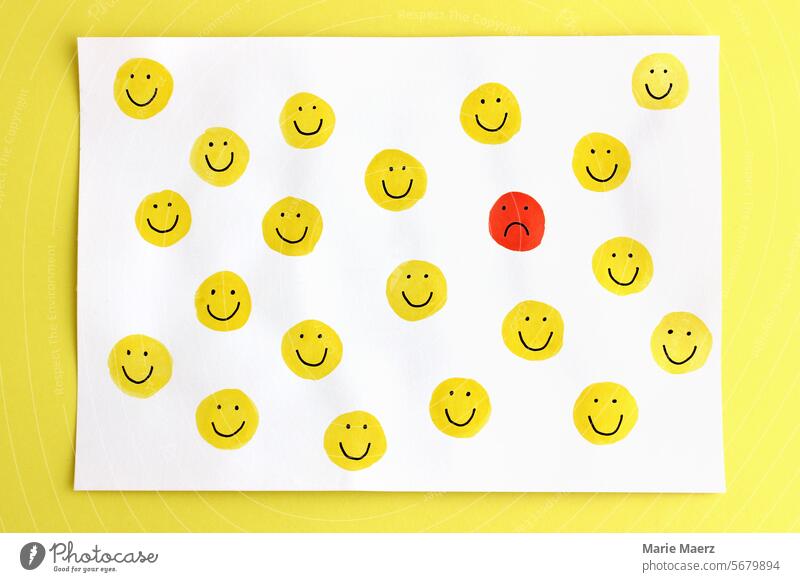 Ein einsames unglückliches Emoticon zwischen vielen glücklich lachenden Smileys Smiley-Gesicht traurig allein Einsamkeit gelb gruppe Emotionen Gefühle Stimmung