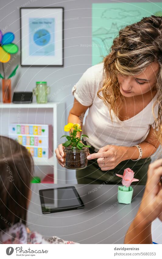 Eine Lehrerin zeigt ihren Schülern im Ökologieunterricht die Wurzeln der Stiefmütterchenpflanze Frau zeigend Zeigen Pflanze botanisch Botanik Blume Klassenraum
