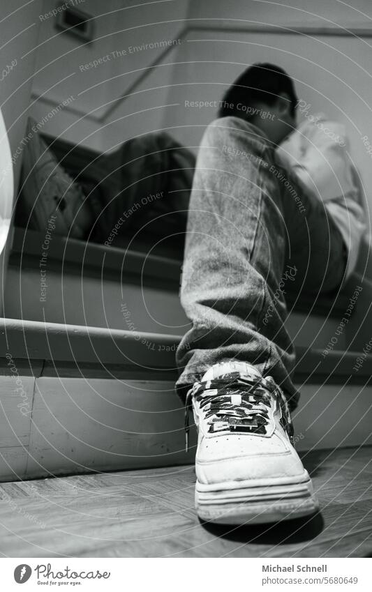 Cooler Jugendlicher sitzt lässig auf einer Treppe jugend Teenager urban modern selbstbewusst trendy Stil jung Lifestyle Coolness Junge moderne Schuhe Mode