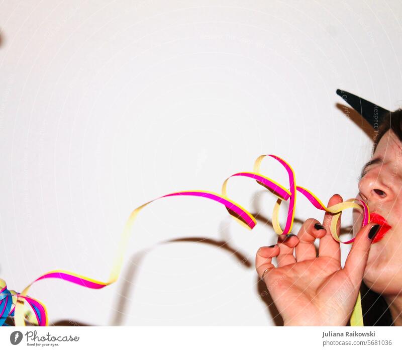 Frau pustet Luftschlangen auf einer Party Kindergeburtstag Geburtstag feiern Februar Stimmung mehrfarbig Vorfreude Girlande Feiern Veranstaltung Lebensfreude