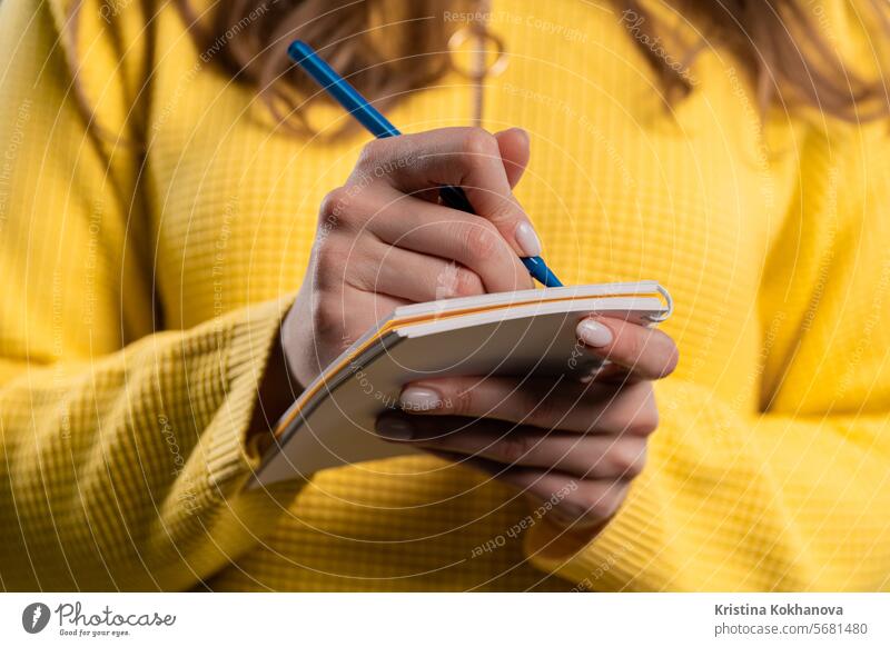 Frau schreibt Notizen in Planer mit Stift. Mädchen denkt an Zukunftspläne, To-Do-Liste Erwachsener Analysieren asiatisch blau Buch Kaukasier Hochschule