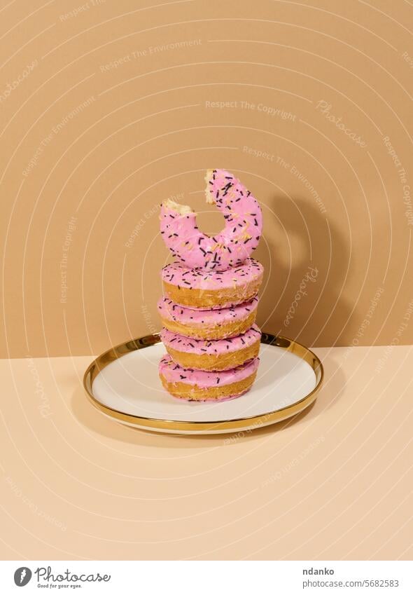 Donut mit rosa Glasur überzogen und mit bunten Streuseln bestreut auf einem runden Teller Krapfen süß Dessert Doughnut Zuckerguß niemand verglast Lebensmittel