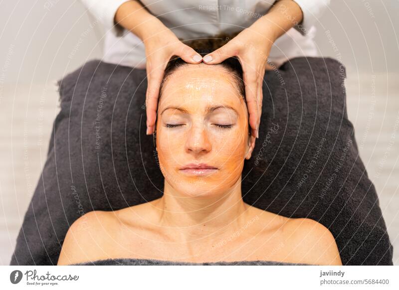 Eine Kosmetikerin massiert eine Kundin im Gesicht mit einer kosmetischen Maske in einem Schönheitssalon Frau Massage Gesichtsbehandlung Verfahren Hautpflege Gel