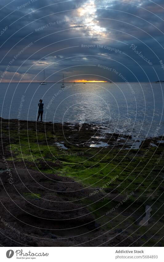 Silhouette einer nicht erkennbaren Person, die am Ufer steht MEER Küste Sonnenuntergang Reisender Boot Abend Wasser Natur stehen allein Meer Meereslandschaft