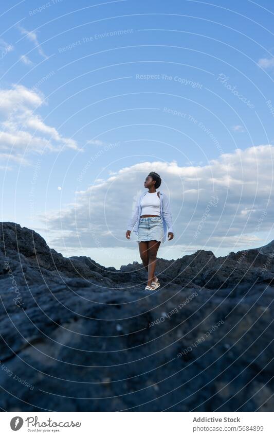 Schwarze Frau, die auf einer felsigen Klippe steht Reisender See Landschaft Berge u. Gebirge Wasser Natur jung Afroamerikaner ethnisch schwarz stehen