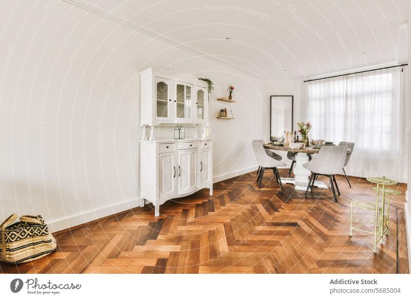 Elegantes Esszimmer mit klassischen Holzmöbeln Innenbereich modern Möbel Holzfußboden Fischgrätenmuster Kabinett weiß elegant natürliches Licht Design