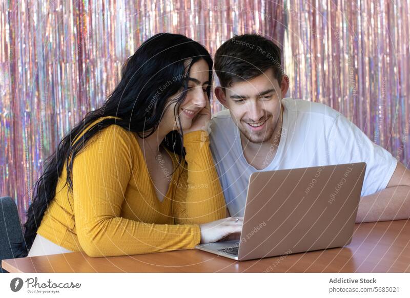 Lächelndes Paar, das Gadgets benutzt und Zeit miteinander verbringt Laptop Glück Apparatur Vollbart Mann Frau Zahnfarbenes Lächeln Freude Zeitvertreib