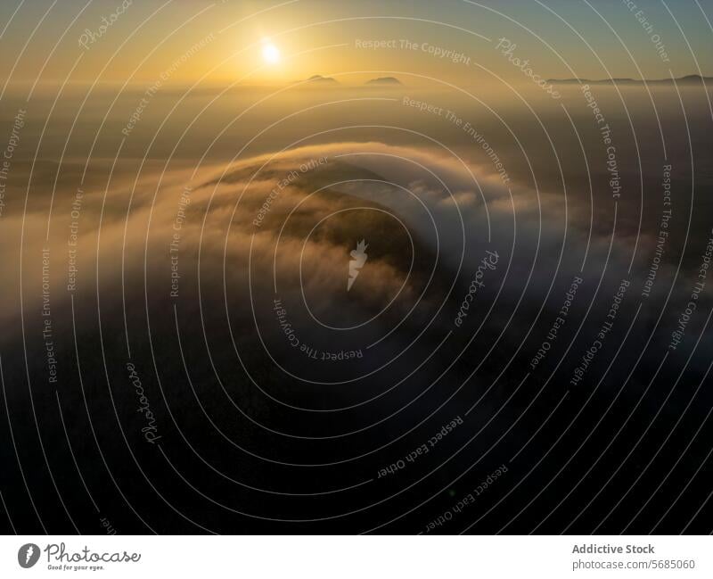 Die Sonne lugt über den Horizont und lässt die nebelverhangenen Hügel Fuerteventuras in einem goldenen Licht erstrahlen. Sonnenaufgang Cloud Tonung Nebel