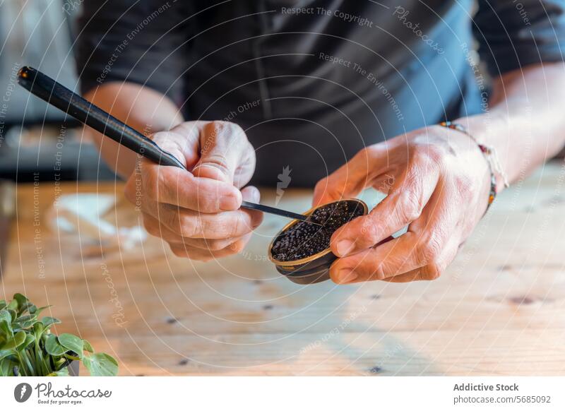 Kappenmann mit schwarzem Kaviar im Glas Mann Küchenchef Speise dienen Restaurant Löffel mischen Schürze lecker Job männlich Arbeit Mahlzeit Uniform kulinarisch