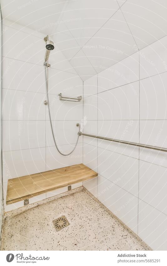 Moderne Dusche mit Sitzbank in einem weiß gefliesten Bad Bank Fliesen u. Kacheln Keramik modern Zeitgenosse hölzern Duschkopf Schlauch Haltegriff Sicherheit