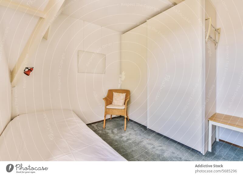 Minimalistische Schlafzimmereinrichtung mit einfachen Möbeln Innenbereich minimalistisch Bett weiß Streu hölzern Stuhl Kissen Wand Rahmen Beleuchtung Design