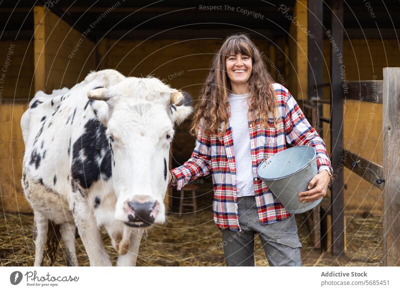 Glückliche Bäuerin mit einer Milchkuh auf einem ländlichen Bauernhof Erwachsener Ackerbau Tier Scheune Business Wade Pflege Streicheln Rind Kaukasier heiter