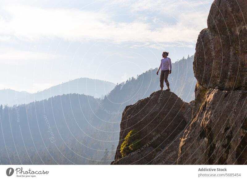Brunet Mann steht auf einer felsigen Klippe im Hochland Tourist bewundern Berge u. Gebirge Turnschuh Landschaft Hose Reisender Natur reisen Urlaub Tourismus