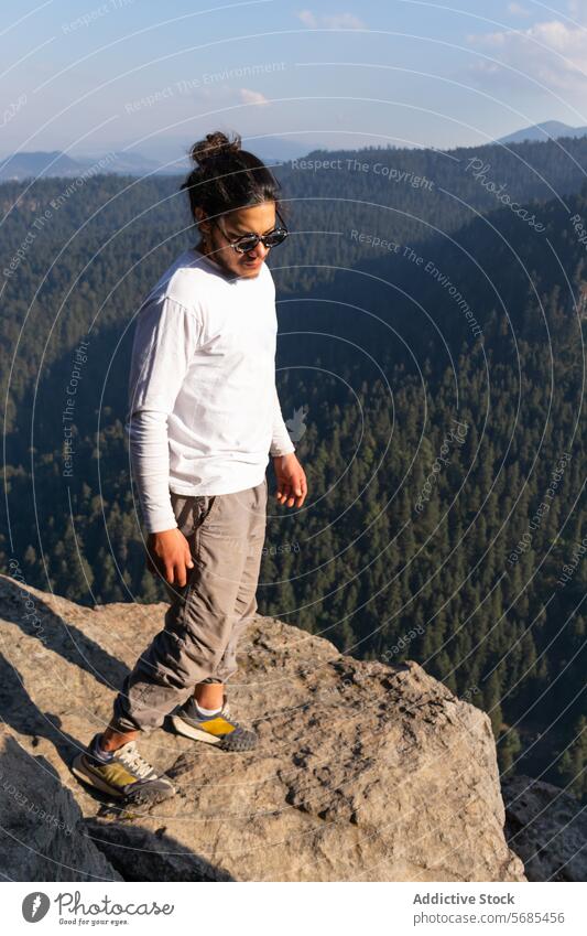 Brunet Mann steht auf einer felsigen Klippe im Hochland Tourist bewundern Berge u. Gebirge Turnschuh Landschaft Hose Reisender Natur reisen Urlaub Tourismus