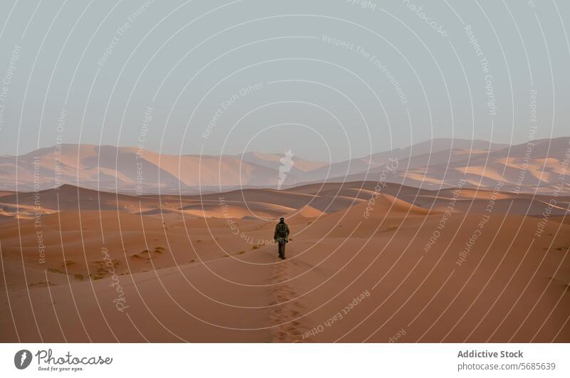Anonymer Einzelreisender beim Trekking durch die Merzouga-Wüste in Marokko Reisender Sanddüne Abenteuer einsiedlerisch Figur Sonnenuntergang Marokkaner