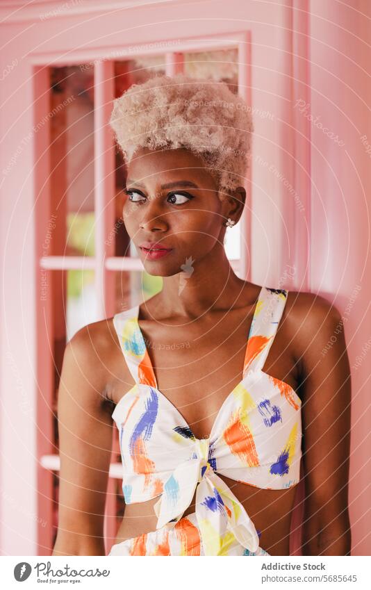 Stilvolle schwarze Frau in Sommeroutfit neben rosa Wand Afro-Look Vorschein jung heiter Make-up Lächeln trendy Glück feminin Afroamerikaner Porträt Frisur