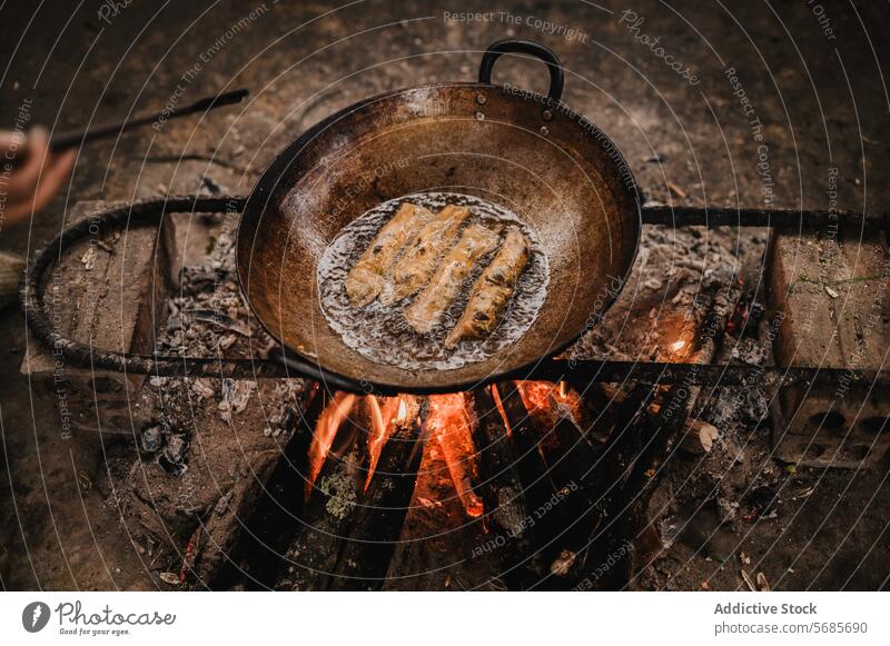 Anonyme Person beim Braten von Frühlingsrollen mit Pfanne Spachtel Hand selbstgemacht Küche Wok braten Feuer vorbereiten Koch Tradition heiß Lebensmittel frisch