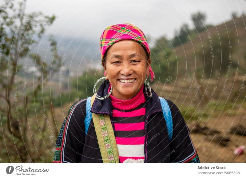 Glückliche ethnische Frau mittleren Alters auf dem Lande Lächeln ländlich Hügel Baum Landschaft Gebäude heiter Natur reif asiatisch Vietnam Asien Kopftuch