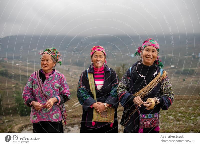 Lächelnde asiatische Frauen mit traditioneller Kleidung in einem ländlichen Tal Tradition Dorf Berge u. Gebirge Landschaft lokal Glück Kultur froh Hochland