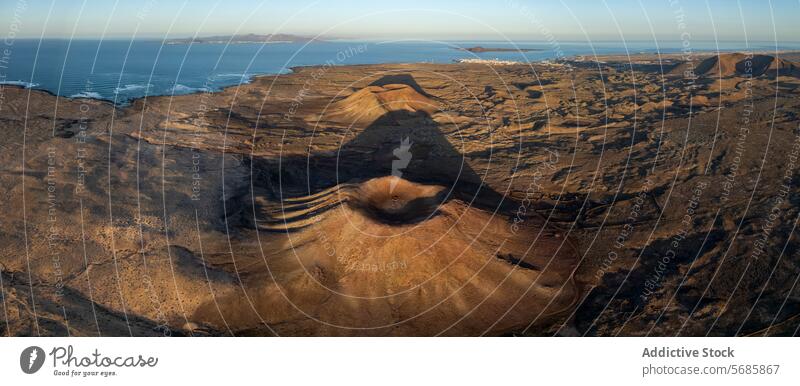 Luftaufnahme einer Vulkanlandschaft und Küstenlinie bei Sonnenuntergang vulkanisch Landschaft Antenne Ansicht warm Licht robust Gelände ausladend Meer Lava Feld