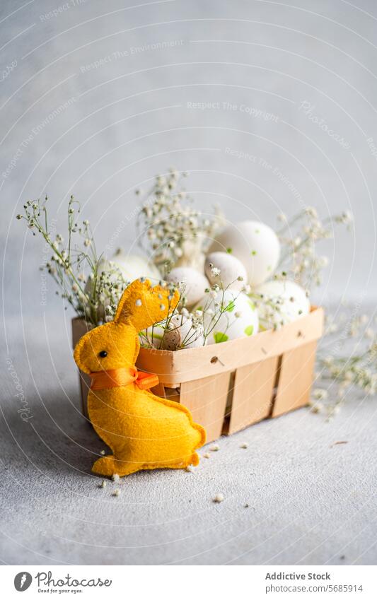 Plüsch-Osterhase mit verzierten Eiern und Atem des Babys Ostern Hase gelb Korb dekoriert Schleierkraut grau Hintergrund Textur Frühling Feiertag festlich