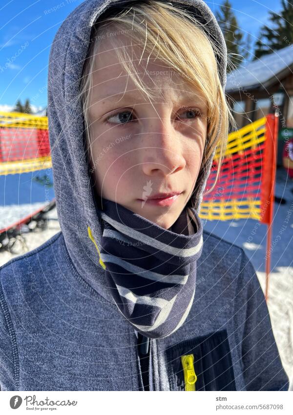 Junge bei der Pause vom Ski fahren Piste Fangnetz Schnee Portrait nachdenklich träumerisch Sonne Berge u. Gebirge Winter Ferien & Urlaub & Reisen Skifahren