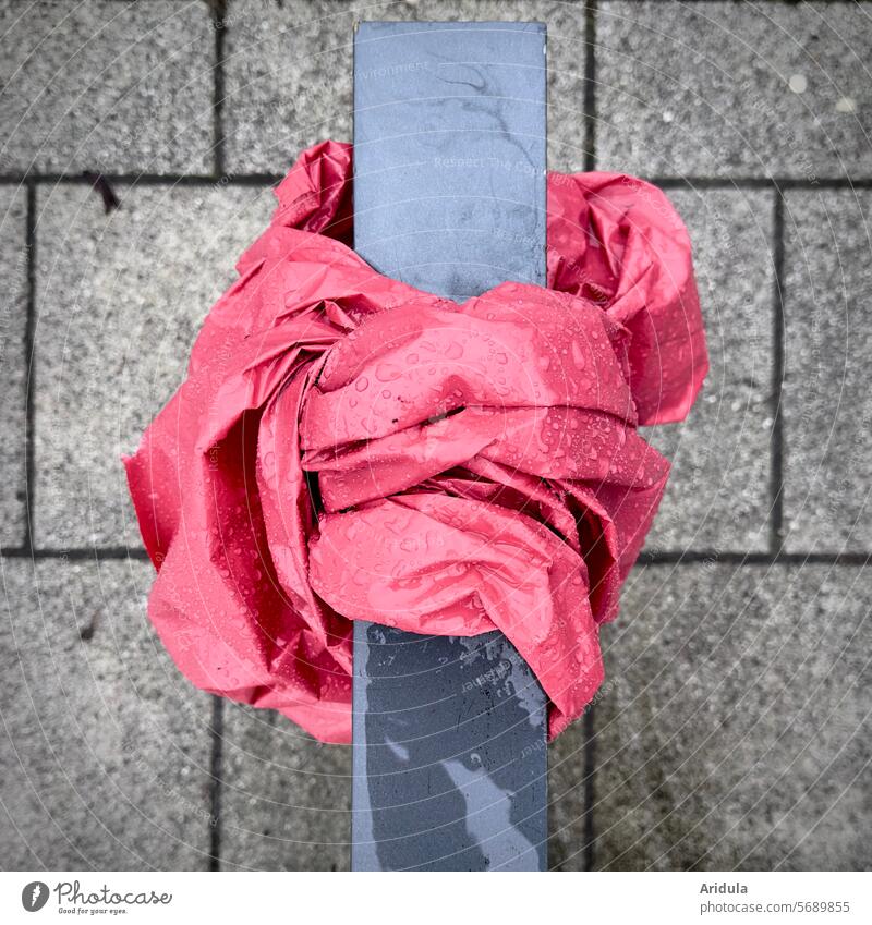 Pinker Kunststoff mit Regentropfen um Fahrradständer gebunden pink Regentopfen skuril Steinplatten Müll Recycling Plastik Verpackungsmüll Strukturen & Formen