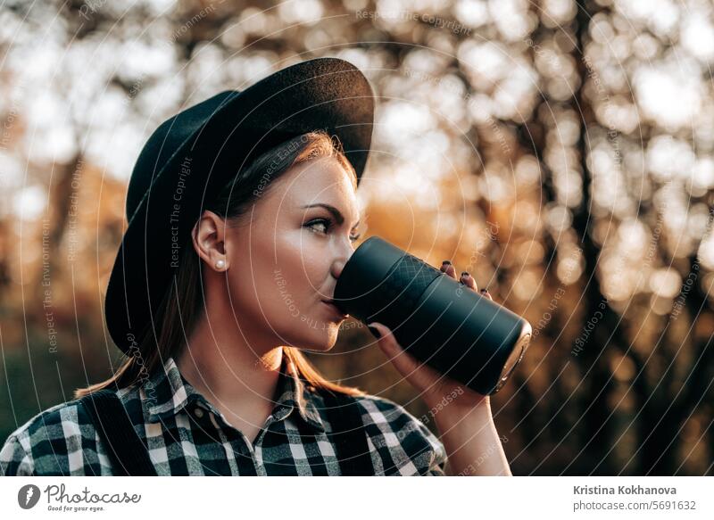 Hipster Frau trinkt heißen Kaffee oder Tee, Thermoskanne, goldenen Park, Wald im Herbst attraktiv Hintergrund schön Getränk Pause sorgenfrei Kaukasier