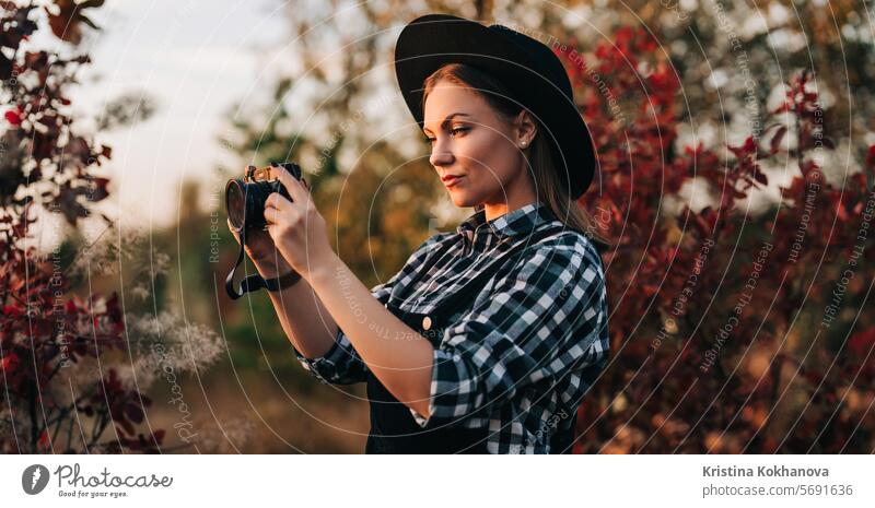 Junge hübsche Frau nimmt Bilder mit DSLR-Kamera im Freien auf Herbst Hintergrund aktiv Erwachsener Kunst attraktiv schön Schönheit Fotokamera Kaukasier heiter