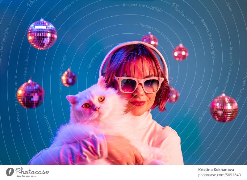 Disco-Frau mit Katze hört Musik mit Kopfhörern, auf Studio-Hintergrund Tanzen genießen Dame jung Kaukasier dj Entertainment Mädchen Party Porträt Erwachsener