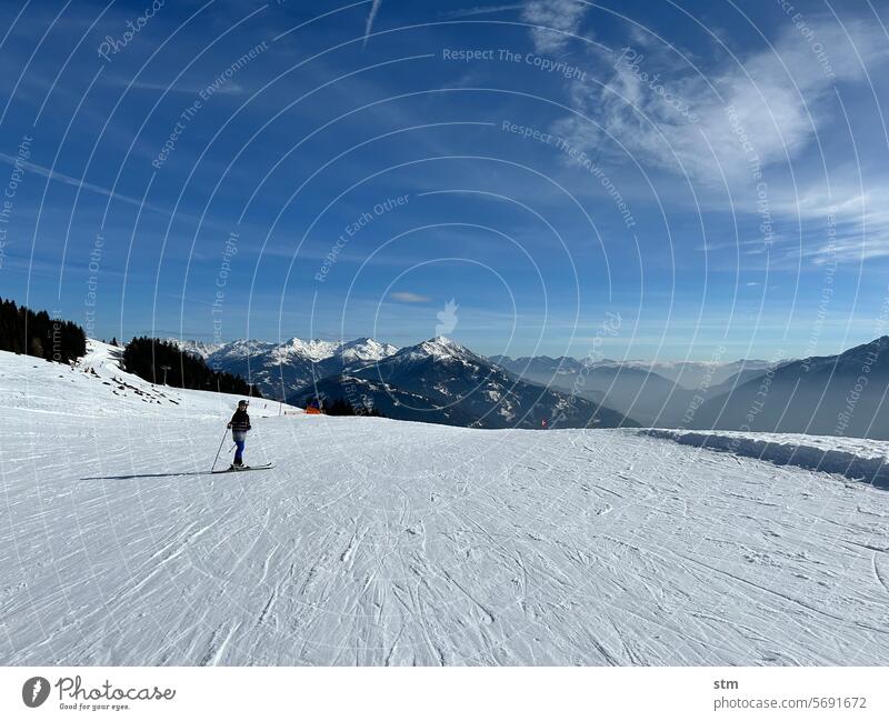Skifahren bei herrlichem Wetter Wintersport Piste Abfahrt Panorama Bergpanorama Dunst Kaiserwetter Schnee Alpen Berge Gipfel verschneite Gipfel Sport Familie